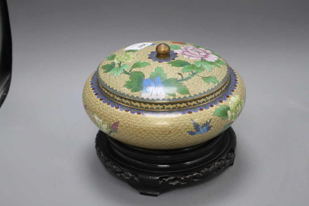 A Chinese cloisonne bowl and cover, decorated with flowers, on ebonised stand, diameter 26cm, overall height 21cm